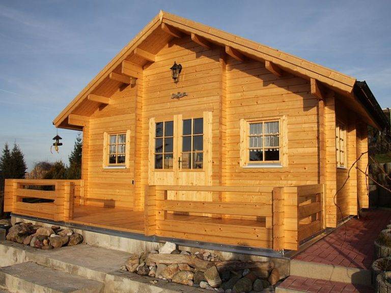 Blockhaus Bodensee: Gemütliches Holzhaus mit Terrasse und Fenstern unter blauem Himmel. Ideal für Urlaub und Entspannung.