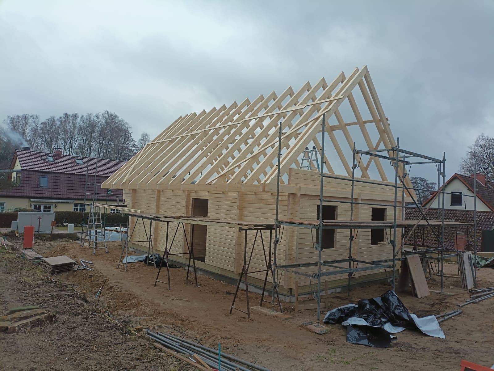 Der Bau eines Wohngebäudes aus Holz ist im Gange, der Dachstuhl ist teilweise fertiggestellt.