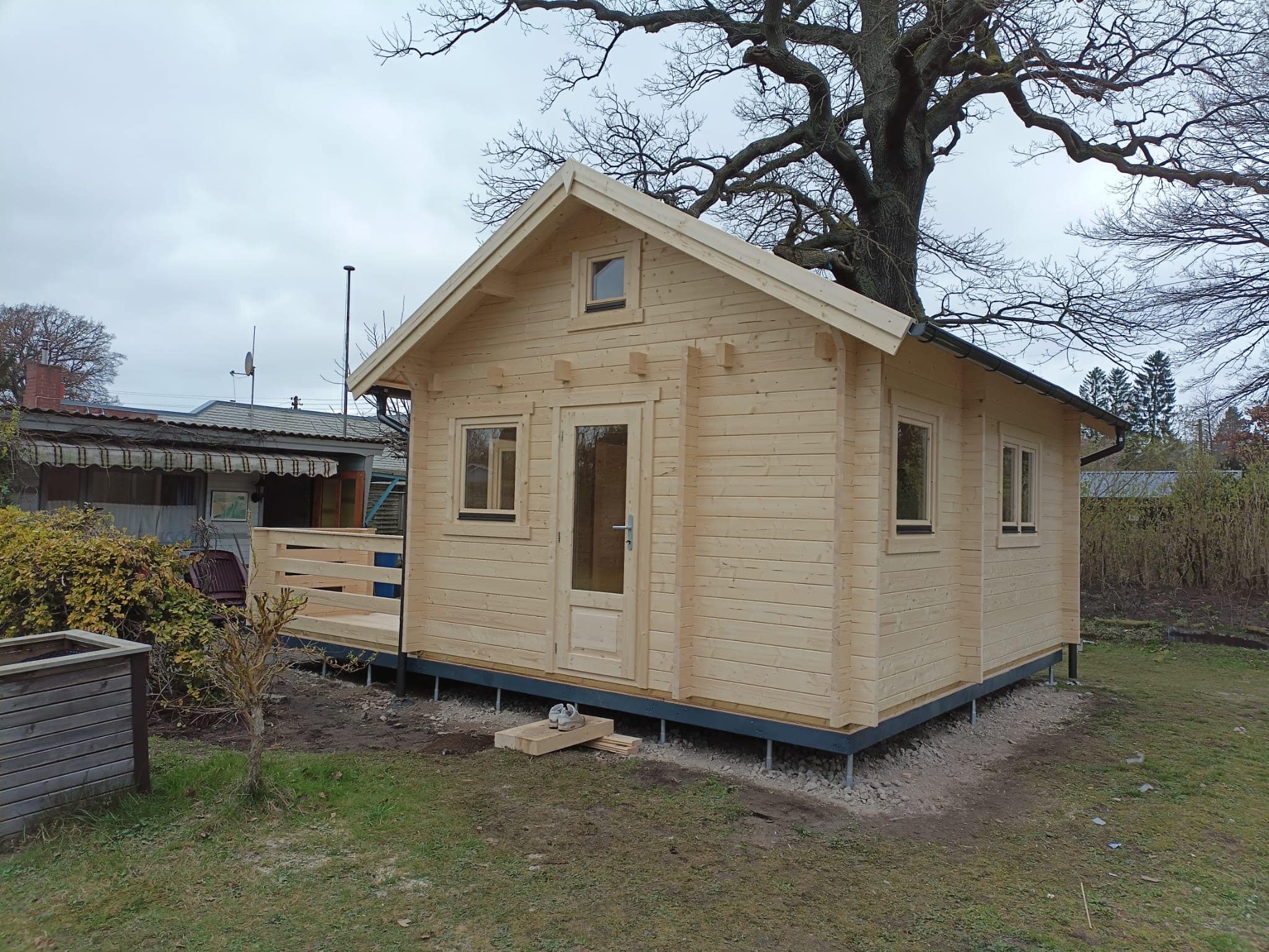 Neu errichtetes Holzblockhaus mit Veranda im Hinterhof.